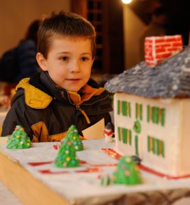 A young visitor admires the Salem Towne House as interpreted in gingerbread by Elinor Celuzza of Sturbridge