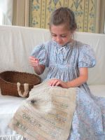 Young girl working on marking sampler